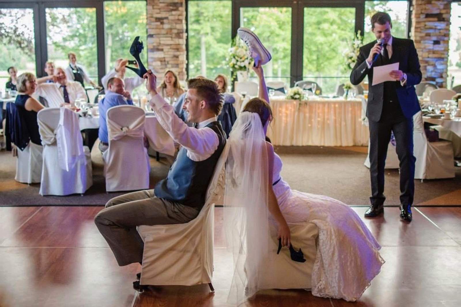 The groom laughing with the bride during a toast
